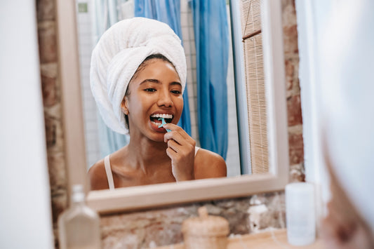 Lady flossing in front of mirror